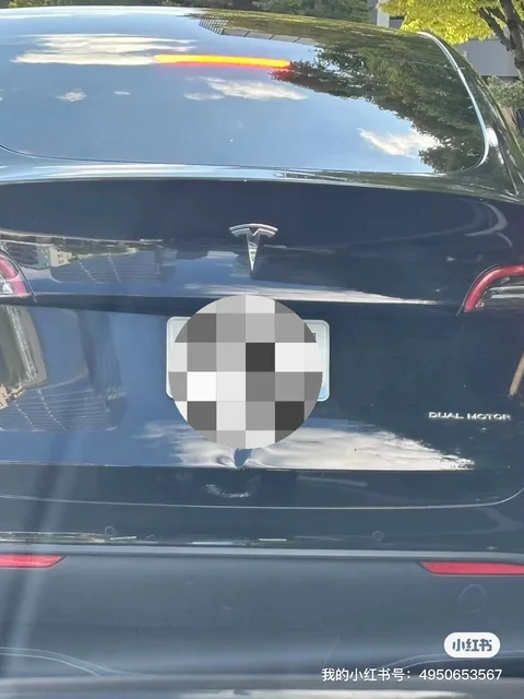 Black Tesla Model Y with a dented trunk