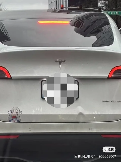 White Tesla Model Y with a dented trunk