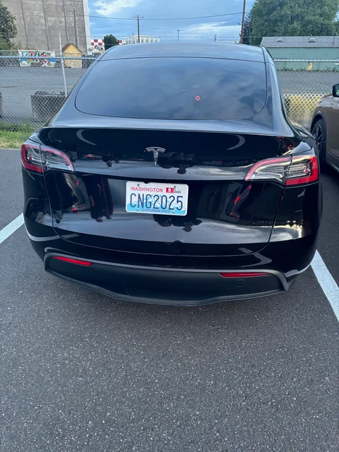 Black Tesla Model 3 with a dented trunk