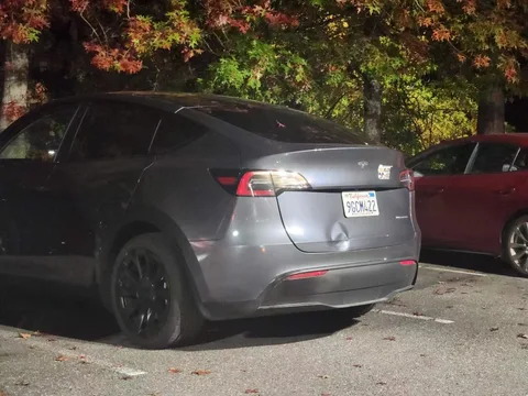Gray Tesla Model Y with a dented trunk