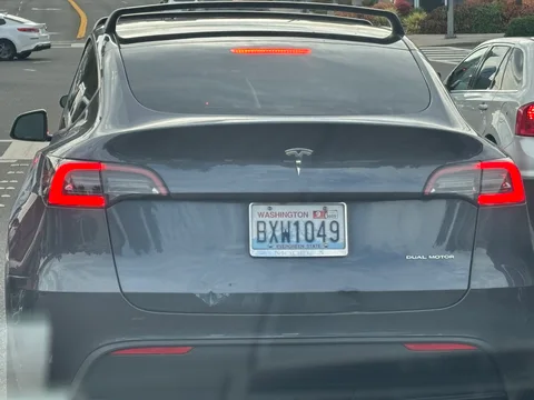 Gray Tesla Model Y with a dented trunk