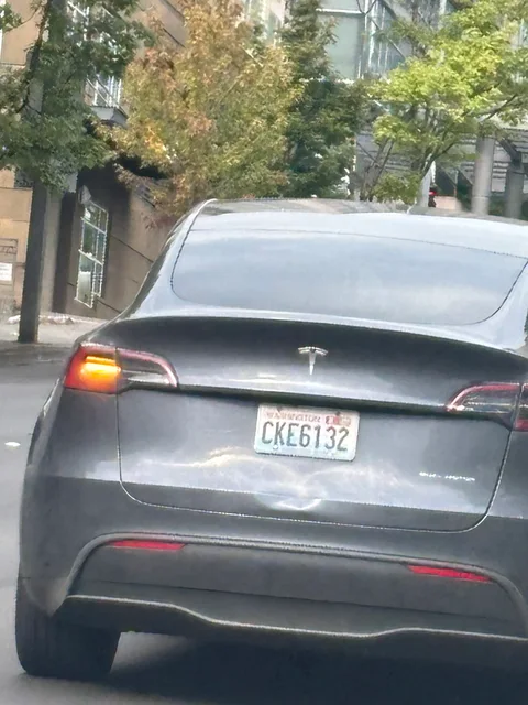 Gray Tesla Model Y with a dented trunk